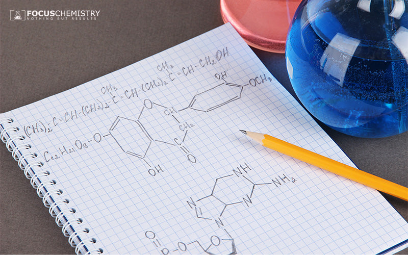Notebook with chemical formulas, pencil, and colorful lab flasks.